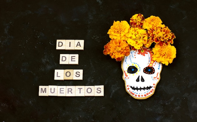 Foto dia de los muertos è una celebrazione messicana. sfondo scuro con teschio di biscotto di zucchero. messa a fuoco selettiva con spazio di copia