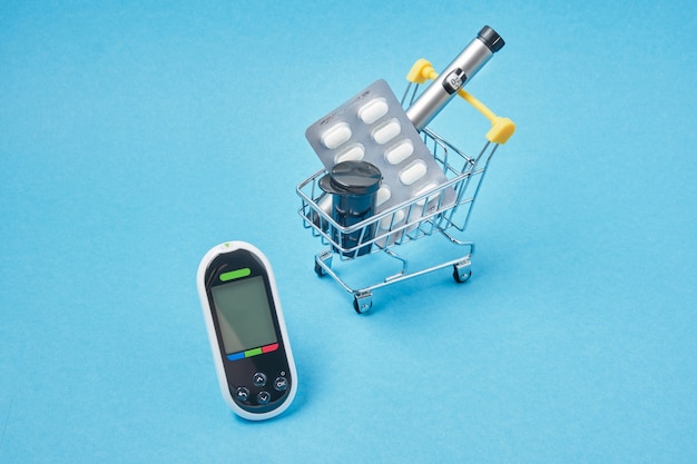 Diabetes concept. Diabetic supplies in shop trolley on a blue background.