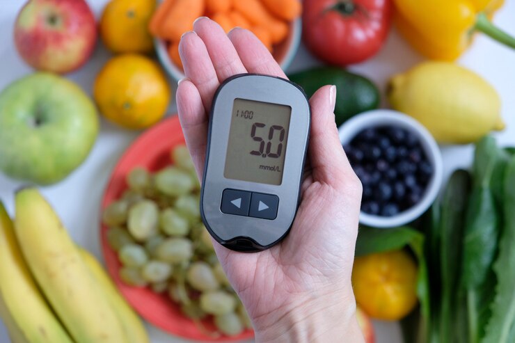 Diabetes concept: glucometer in hand and healthy food.
