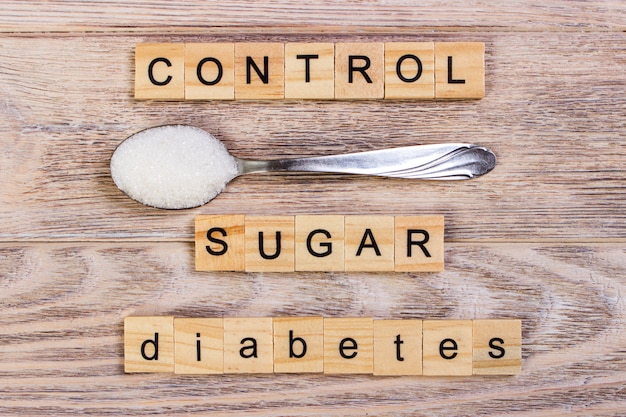 당뇨병 제어 블록 나무 편지와 숟가락에 설탕 더미