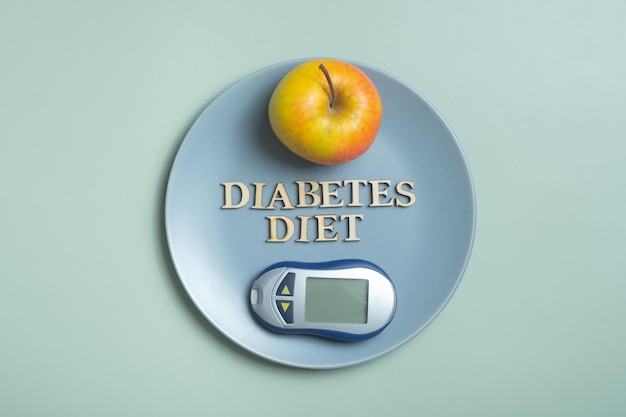 Diabetes Dieetplan tekst Glucometer en bord met appel op gekleurde achtergrond plat bovenaanzicht