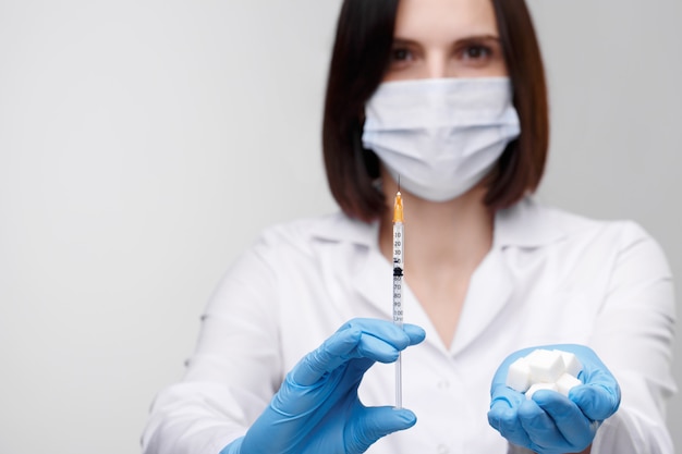 Diabetes,insulin,high blood sugar. Medical injection,diseases,health care.Doctor or nurse in hospital holding a syringe with liquid vaccines preparing to do an injection.People in white uniform,robe