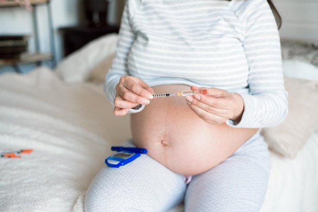 Foto diabete della penna di insulina in gravidanza donna in gravidanza con siringa.