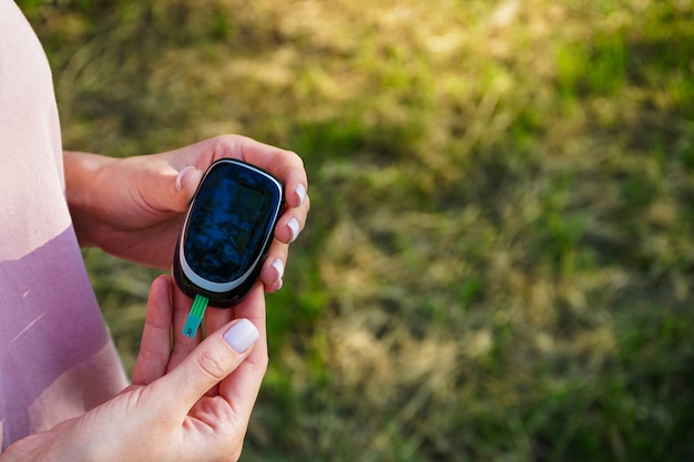 Diabetesconcept van glucometer in de handen van een vrouw voor suikercontrole