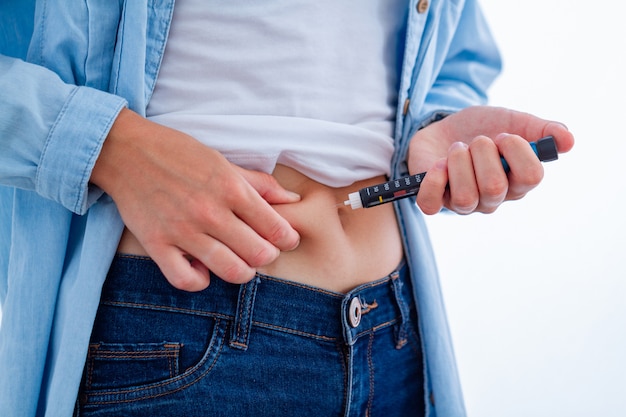 Photo a diabetic patient makes an insulin injection with insulin pen at home