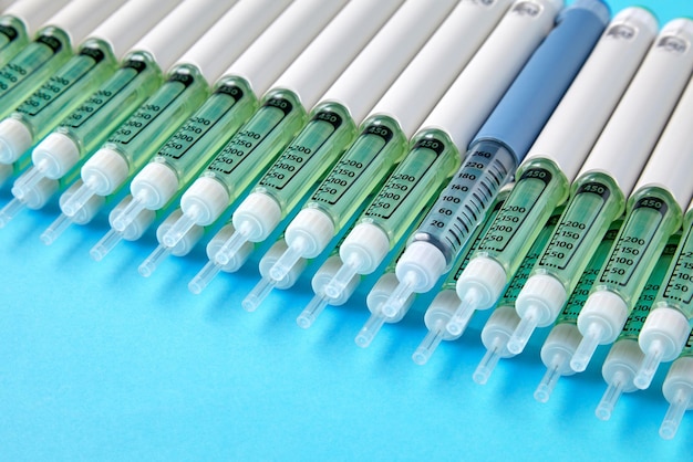 Diabetische insulinepennen opgesteld op een blauwe achtergrond Verstrekking van geneesmiddelen voor diabetespatiënten