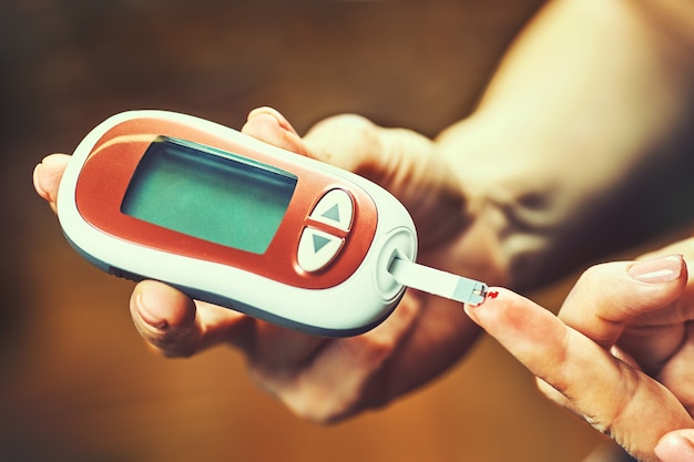 Diabetische vrouw die bloedglucosemeter gebruikt, vrouwelijke handen houden lancetpen glucometer op vingermaat suikercontrole insuline