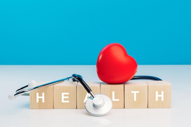 Diagnose cardioloog concept Tekstgezondheid op houten kubusblokken met rood hart en stethoscoop op blauwe achtergrond Apparatuurcontrole hartslag en pols van de patiënt