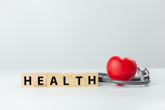 Photo diagnosis cardiologist concept text health on wooden cube blocks with red heart and stethoscope on white background equipment check heartbeat and pulse of patient