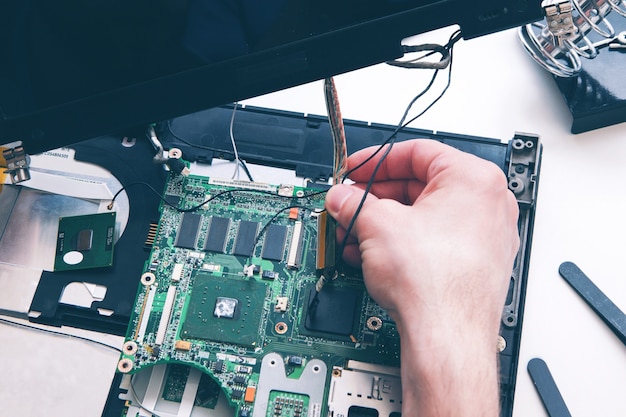 Foto diagnostica, riparazione, concetto di servizio laptop. scheda madre dal computer, pc nella vista dall'alto dell'officina di riparazione