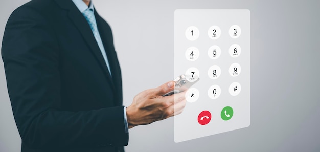 Dialing on virtual telephone keypad with transparent telephone buttons businessman touch Emergency button of telephone number on screen Finger touch number on smartphone to make a call close up