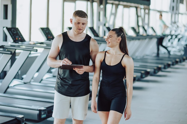 Photo dialogue and assistance personal trainer explains exercises to female client