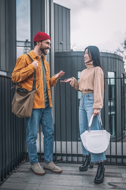 Dialogue. Young man and woman in casual clothes talking outside