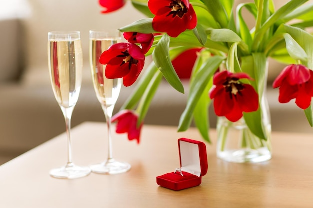 Diamanten ring, champagne en bloemen op tafel.