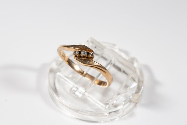 Diamond ring. Diamond ring on white background. Ring with three diamonds. Golden wedding rings. Yellow gold.