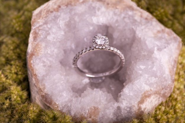 A diamond ring sits in a rock with the word diamond on it.