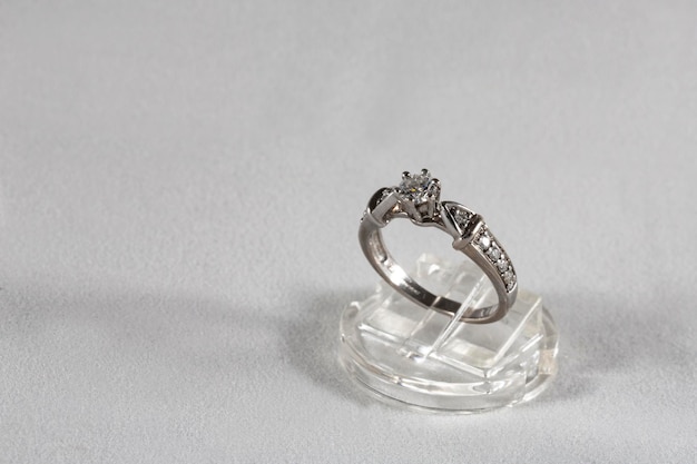 Diamond ring witgouden ring met natuurlijke diamanten op een sieradenstandaard op een grijze achtergrond