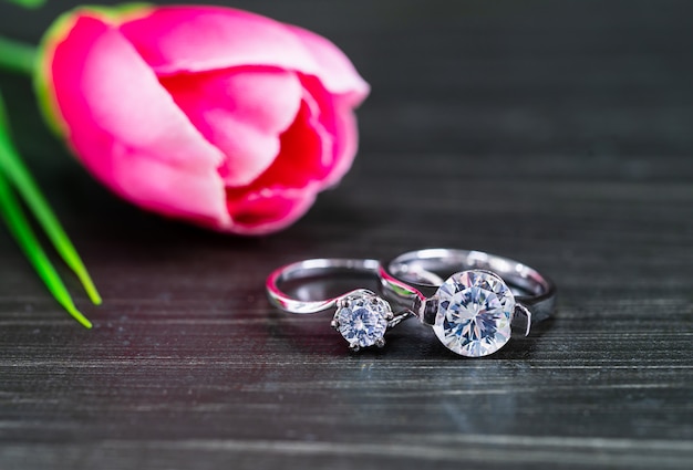 Diamond wedding rings with tulip flower on black background