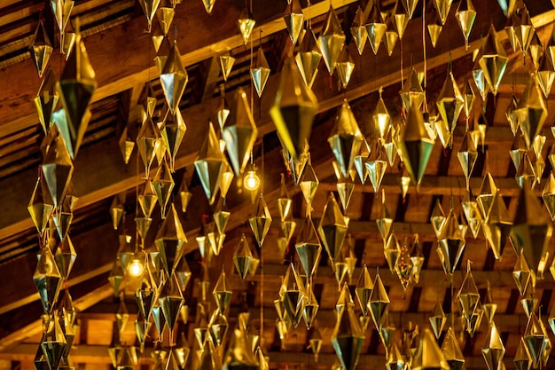 Diamonds or golden geometric shapes hanging from the wooden ceiling of the granollers porch followed