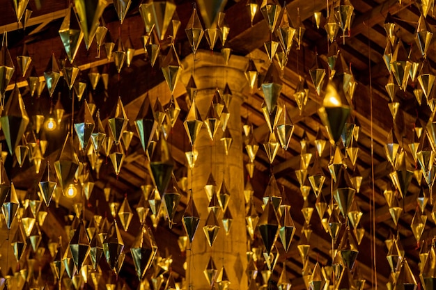 Diamonds or golden geometric shapes hanging from the wooden ceiling of the granollers porch