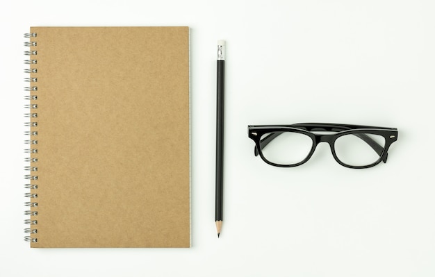 Diary book, pencil and a glasses on white background