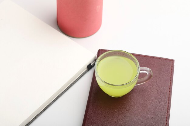 Diary and pen with cup of green tea