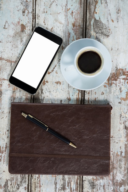 Diary, smartphone and pen with coffee cup