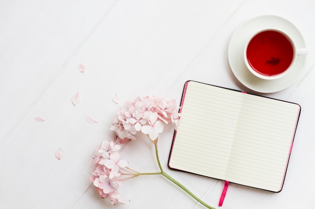 Diary with cup of tea and flowers