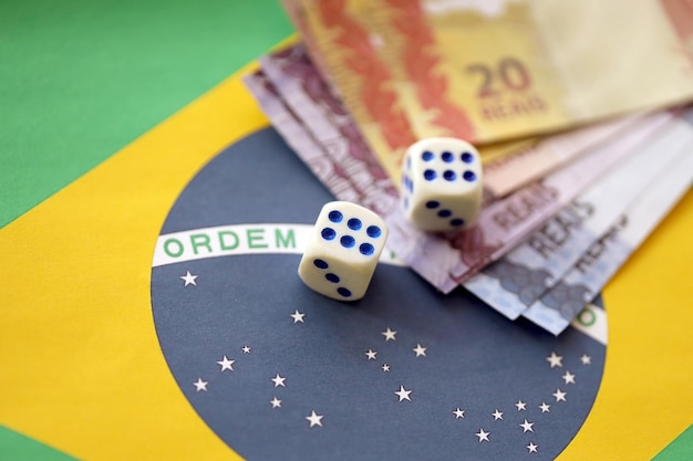 Dice cubes with brazilian money bills on flag of Brasil Republic Concept of luck and gambling in Brasil