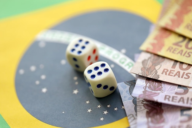 Dice cubes with brazilian money bills on flag of Brasil Republic Concept of luck and gambling in Brasil