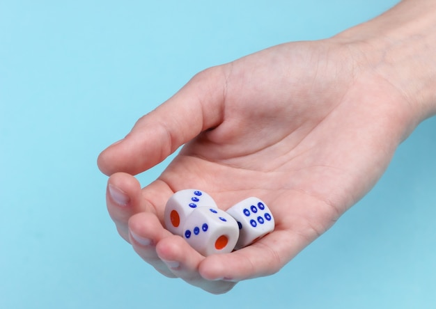 Dice in hand close-up on a blue