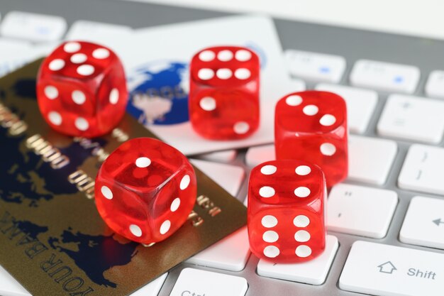 Photo dice plastic credit bank cards and computer keyboard on table online gambling concept