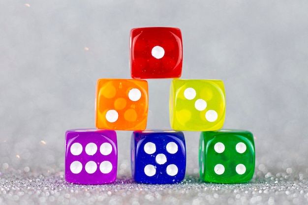 Dice pyramid with the colors of the rainbow flag on a silver background