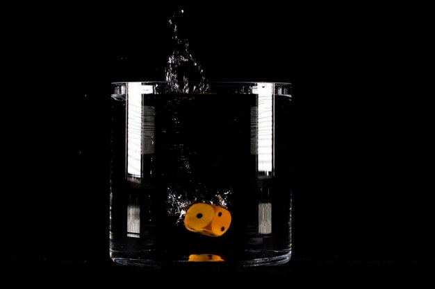 Photo dice in water splash on black background