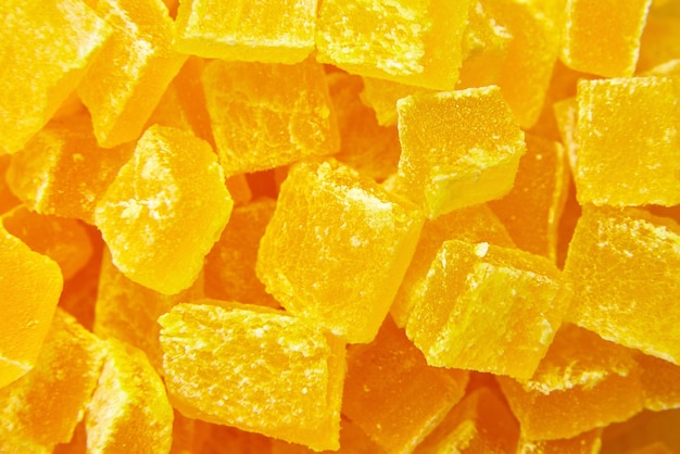 Diced mango dried fruits texture background top view dehydrated mango chips dices sweet food closeup