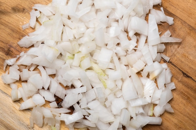 Diced onion on a wooden cutting board Sliced white onion