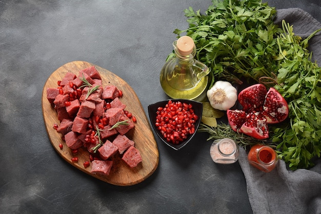 Photo diced raw beef with ingredients, herbs, spices and pomegranate.