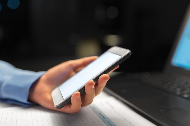 dicht bij de hand met smartphone op het kantoor's nachts