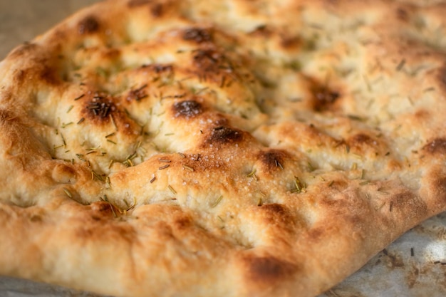 Dichtbij beeld van typisch Italiaans Focaccia Brooddeeg met olie en rozemarijn gebakken