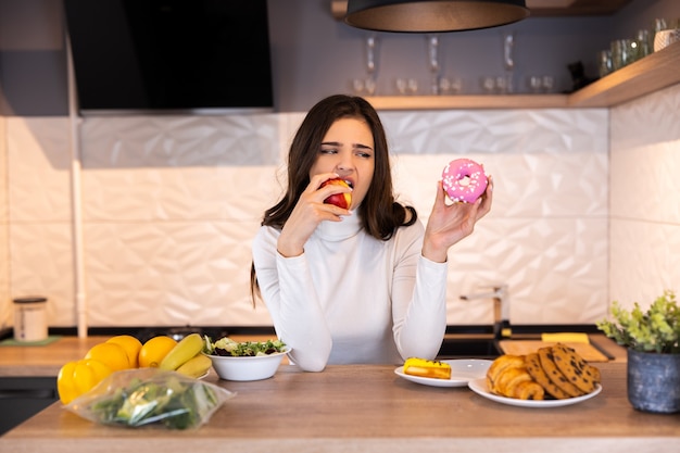 Dieet Concept. Jonge Vrouw Kiezen Tussen Fruit En Snoepgoed.