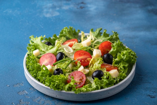 Dieet gezonde salade met greens cherry tomaten ui kaas en zwarte olijven Copy space