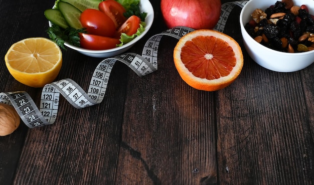 Dieet gezondheidszorg groenten fruit centimeter tape op een donkere achtergrond