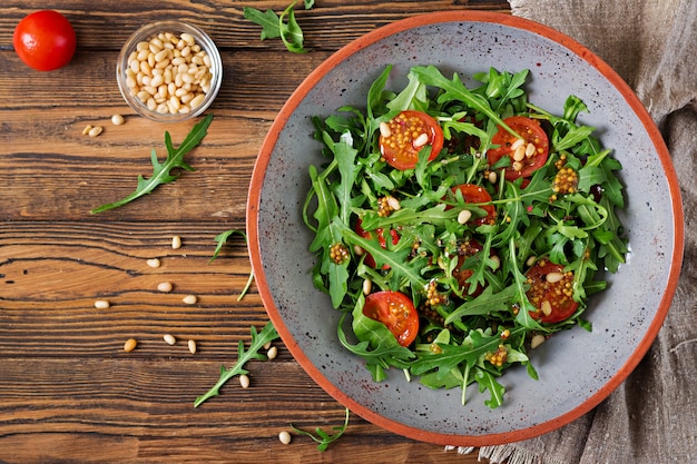 Dieet menu. Veganistische keuken. Gezonde salade met rucola, tomaten en pijnboompitten. Plat leggen.