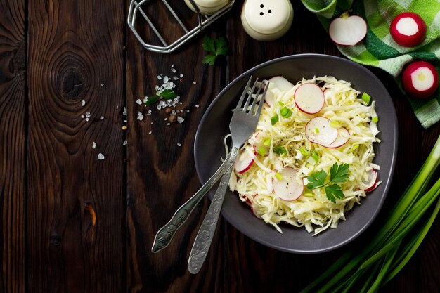 Dieetconcept van vegetarisch eten Zomersalade met verse kool en radijs op tafel