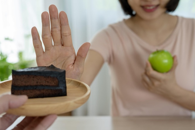 Dieetconcept vrouwen weigeren chocoladetaart en eten salade voor een goede gezondheid