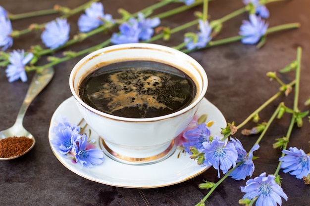Dieetdrank witlof in een kopje - koffiesurrogaten, poeder en bloemen. Kruiden drank. Selectieve focus
