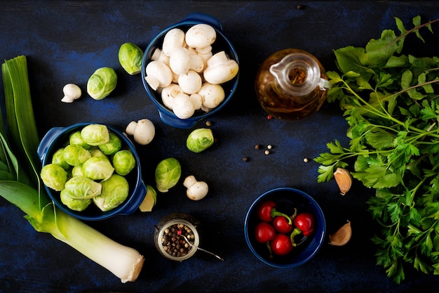 Dieetmenu. Ingrediënten: Groenten - Spruitjes, Champignons, Prei en Kruiden op een donkere achtergrond. Bovenaanzicht. Groentenmenu.