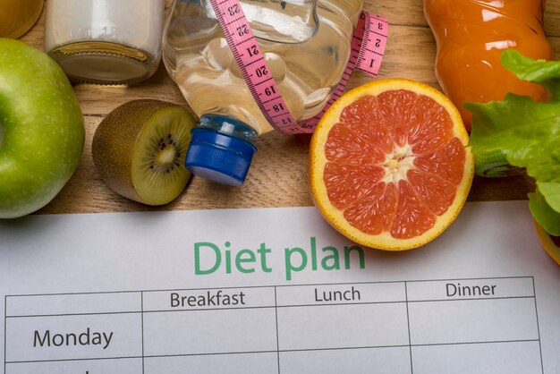 Foto dieetplan meetlint waterdieet van vers fruit op de houten vloer