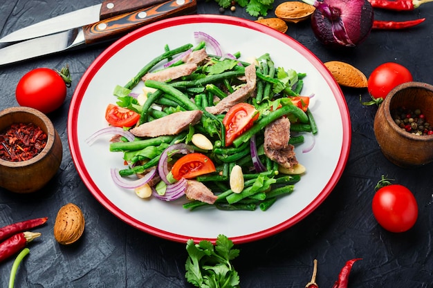 Dieetsalade met kalfstong, aspergebonen, tomaat, kruiden en amandelen.