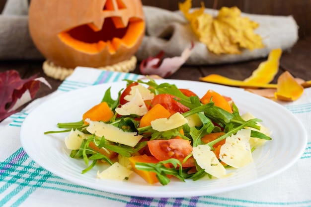 Dieetsalade met pompoen, verse tomaten, rucola en Parmezaanse kaas.